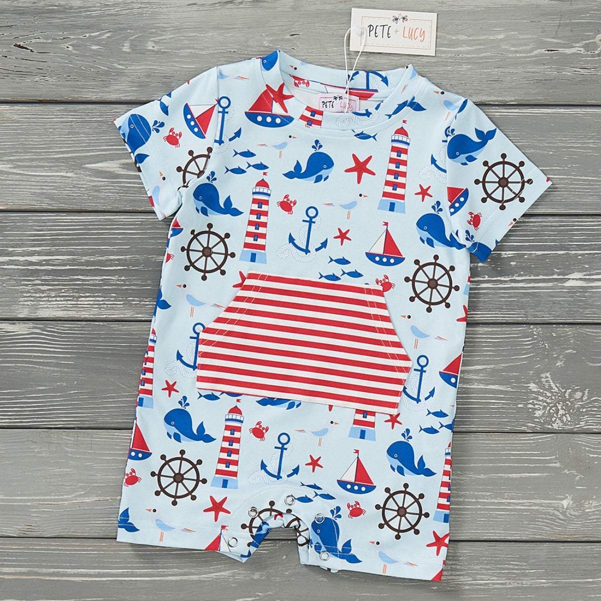Nautical-themed boy romper with whales, anchors, and lighthouses, made from P-Lush fabric.