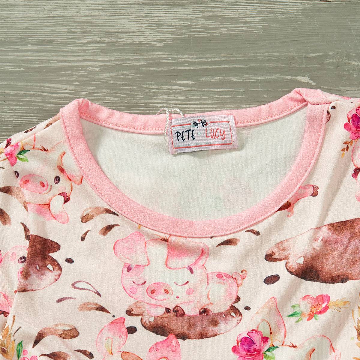 Charming Charlotte Dress with playful piglet and floral print, featuring a pink trim and jewel neckline.