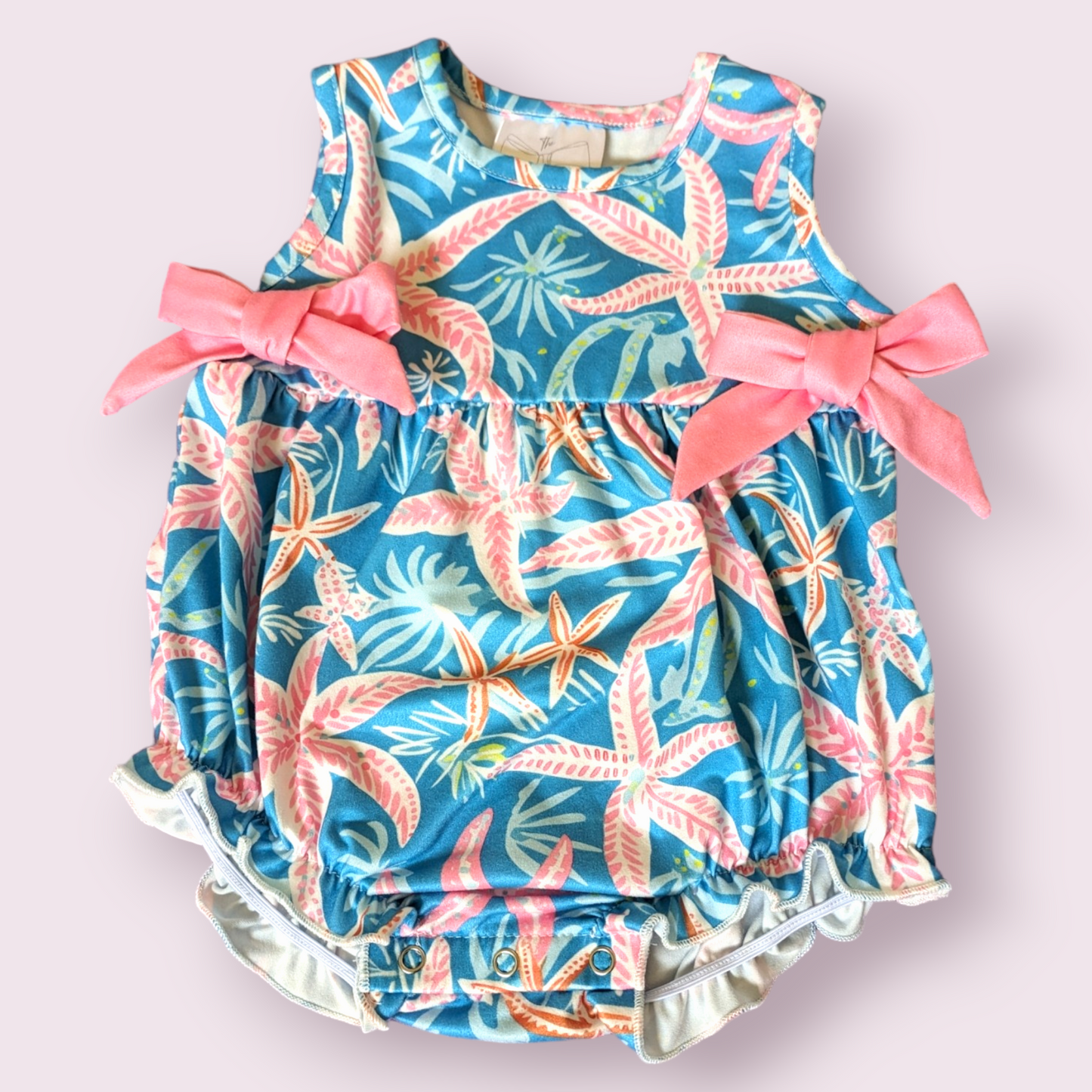 Starfish Galore Infant Romper with pink bows, starfish pattern, and sleeveless design.