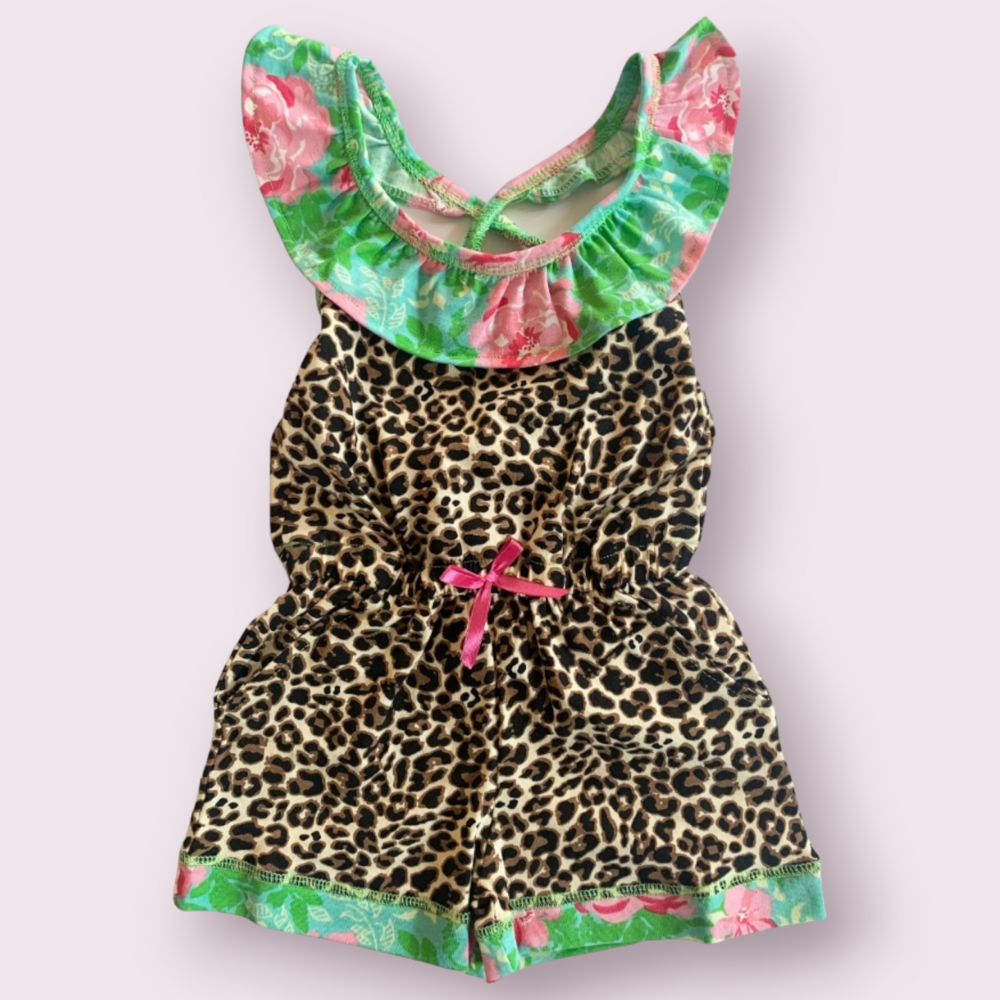 Leopard floral print shorts jumpsuit with ruffled neckline and cross-back straps.