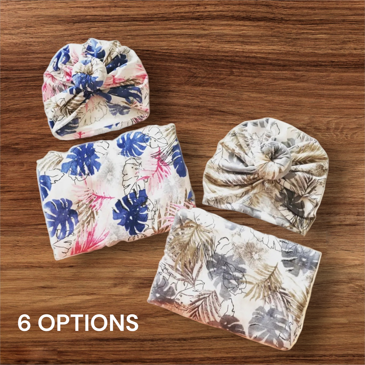 Newborn floral swaddle set with hats, featuring soft cotton material in two styles on a wooden surface.