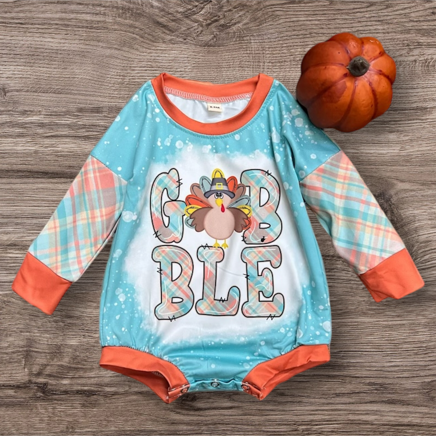 Gobble Turkey Baby Romper with cute turkey graphic and plaid sleeves.