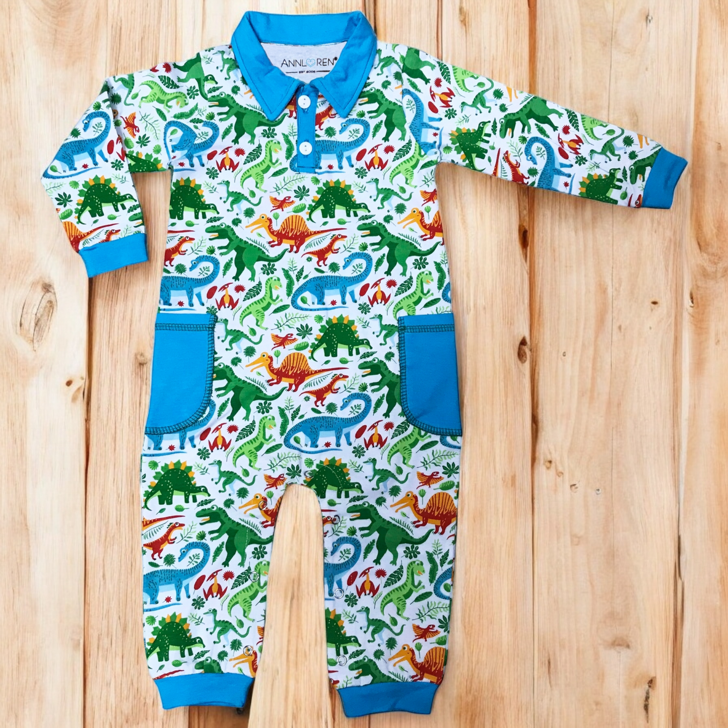 Dinosaur print boy's long sleeve romper with blue collar and cuffs.