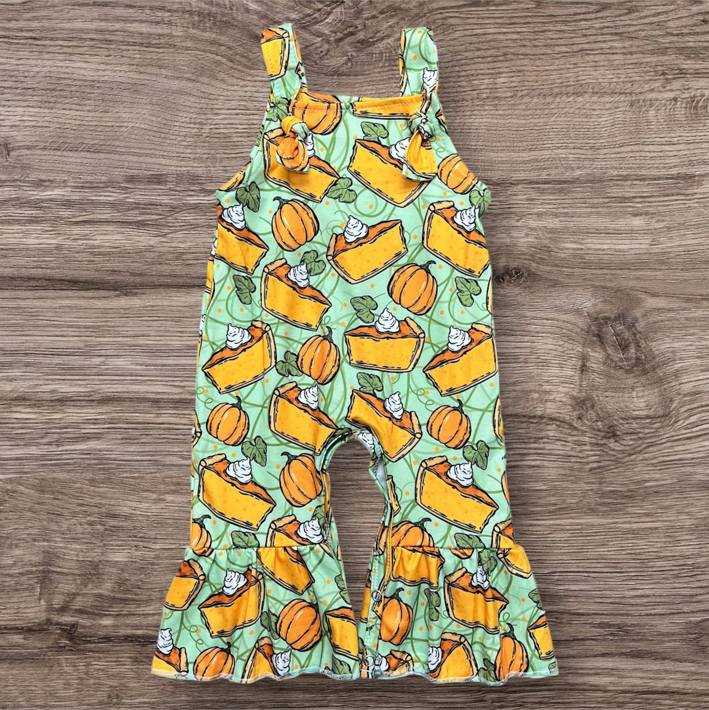 Pumpkin Pie Baby Romper with pie and pumpkin print, snap closure, and adjustable tie straps.