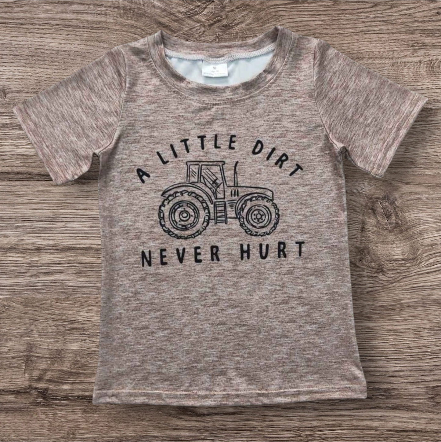 Brown Tractor Top featuring a tractor graphic and "A Little Dirt Never Hurt" text, made from 95% cotton and 5% spandex.