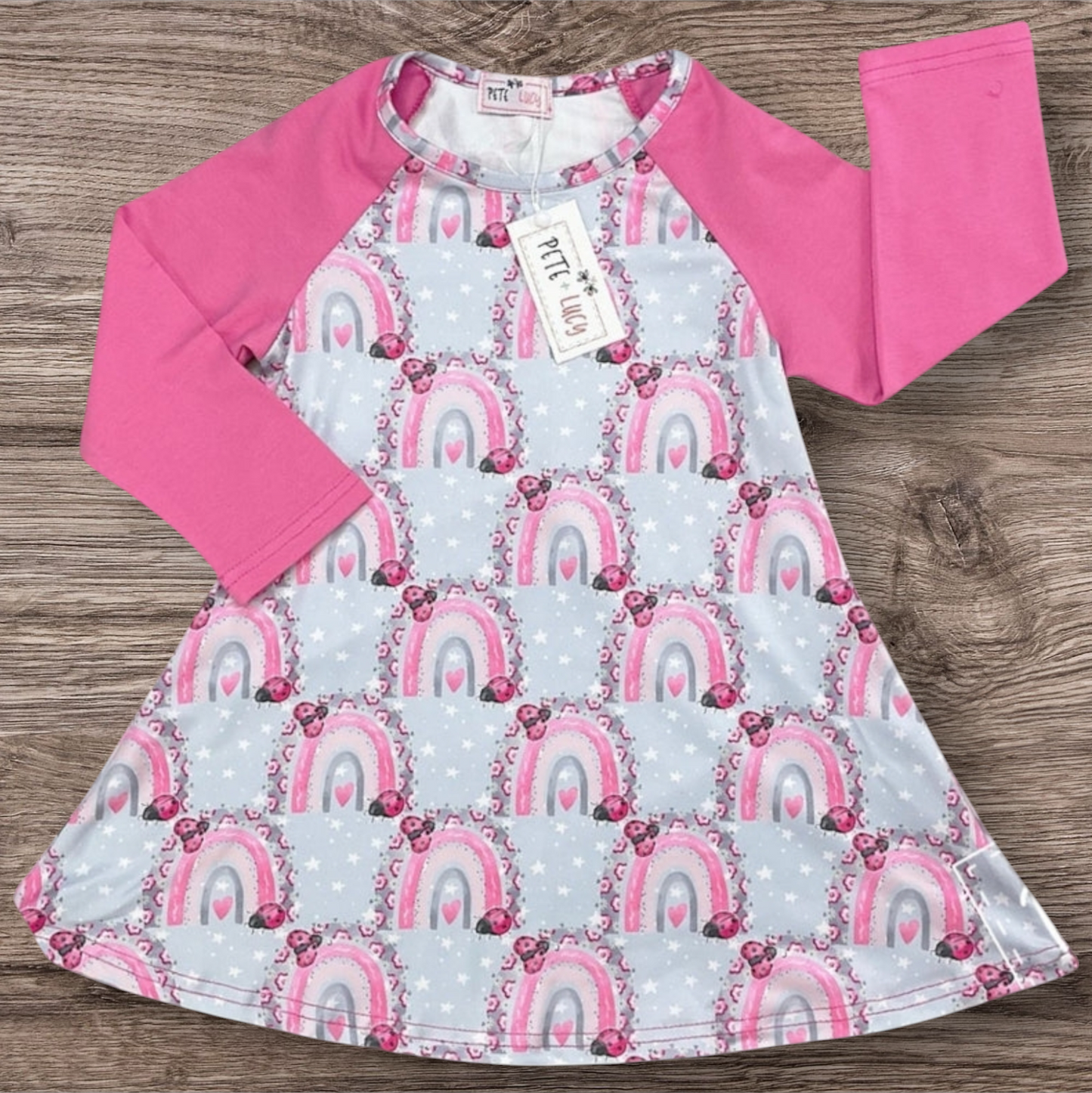 Lucky Ladybugs Dress with pink sleeves and rainbow ladybug print.