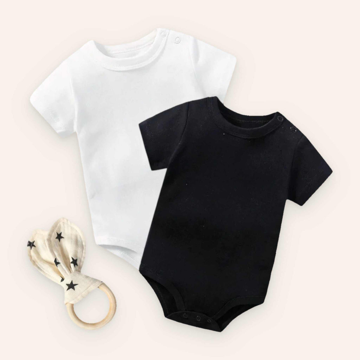 Baby bodysuit set with white and black bodysuits and rabbit ear teether.