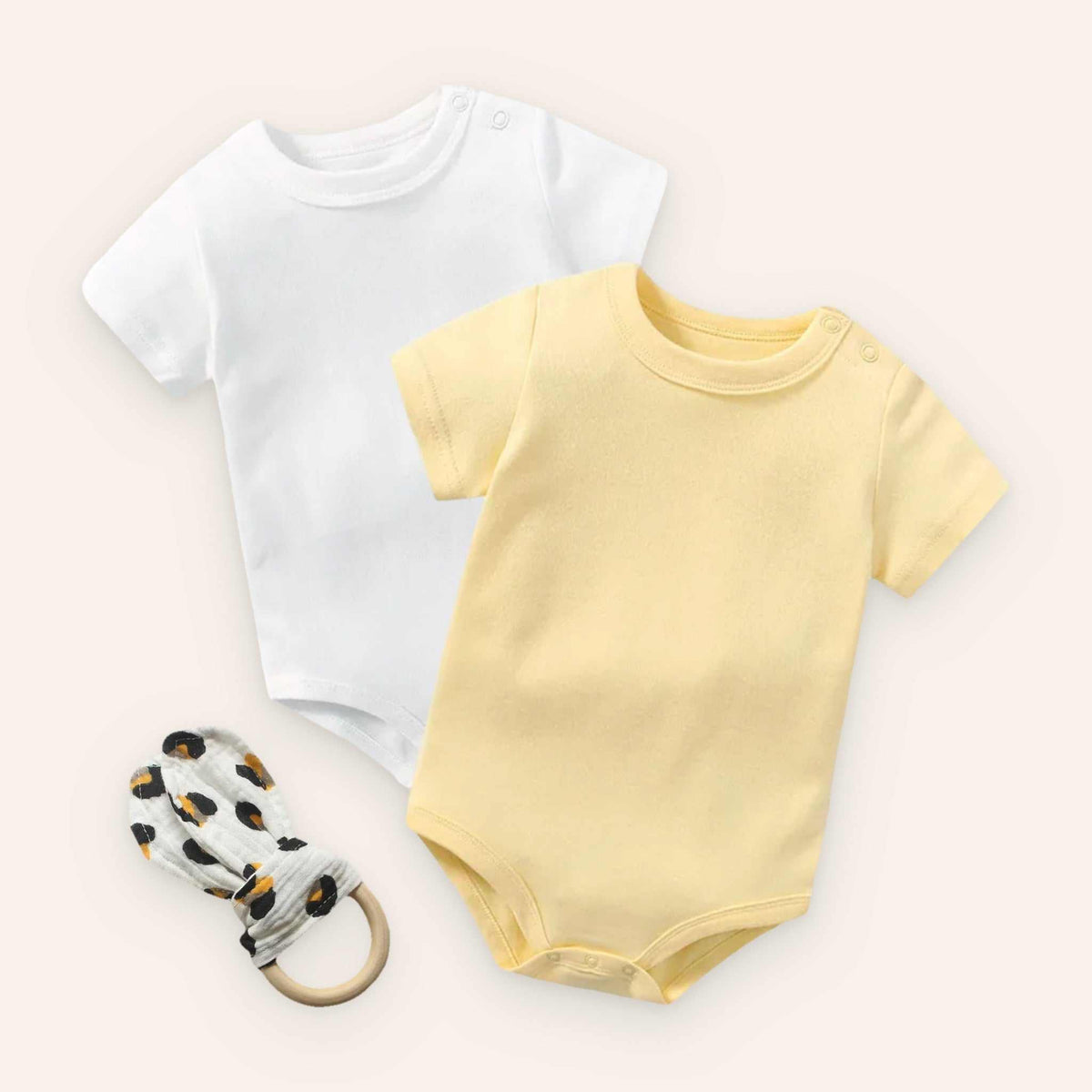 Baby bodysuit set with teether; includes white and yellow bodysuits plus a rabbit ear teether; soft cotton fabric.