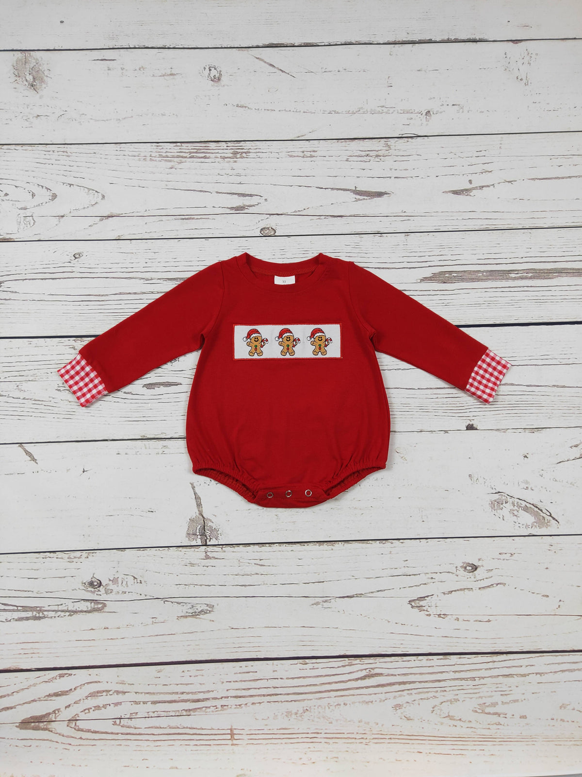 Baby Boys Gingerbread red long-sleeve romper with a chest panel of gingerbread figures and red-and-white check cuffs.