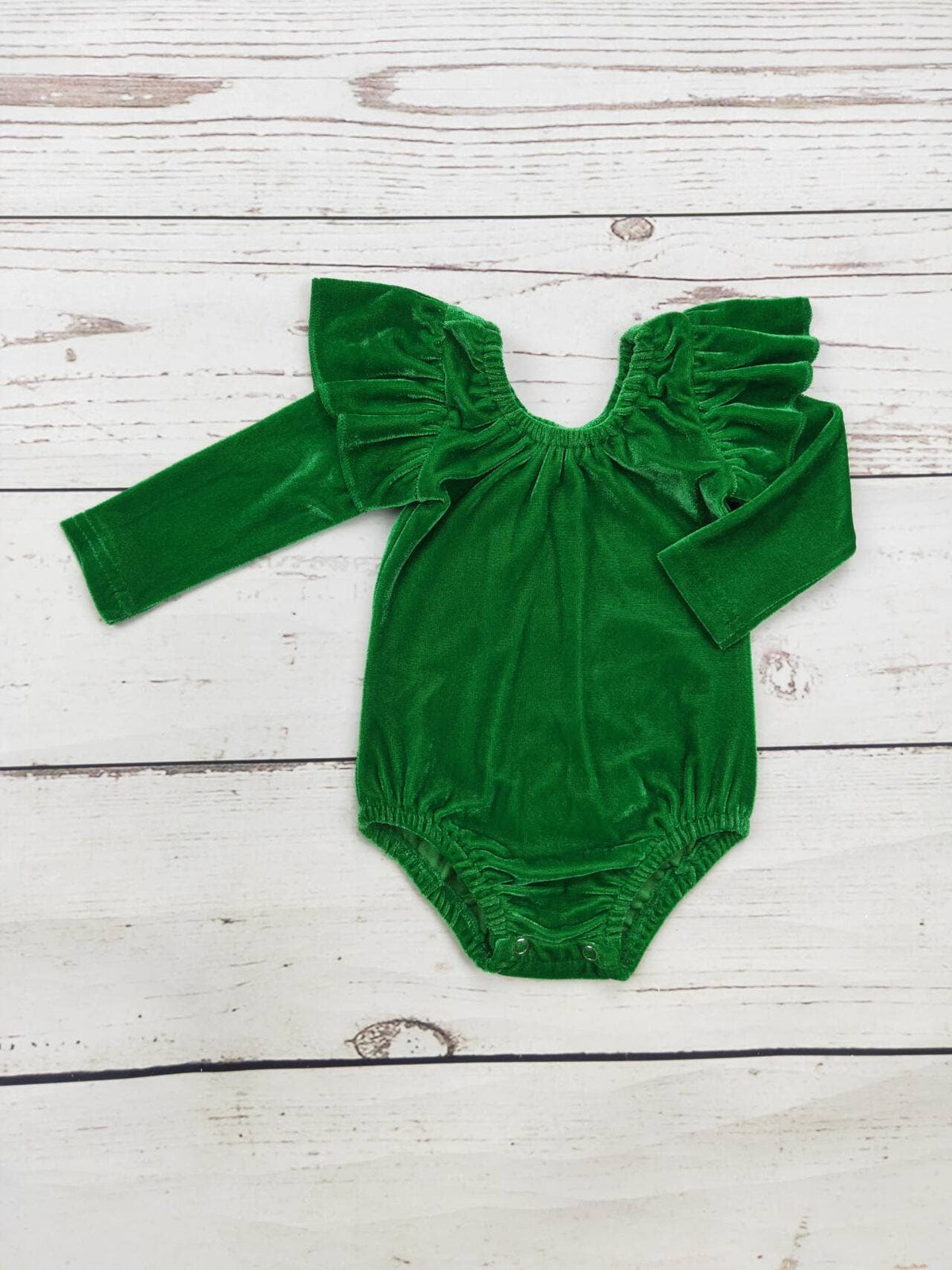 Baby Green Velvet Onesie in rich emerald green velvet, with long sleeves, gathered ruffle shoulders, and snap-button crotch closure.
