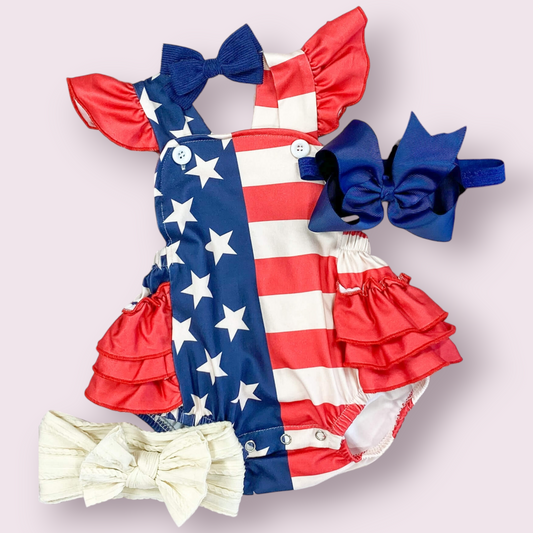 July 4th American Flag romper with adjustable straps and ruffles, shown with bows (not included).