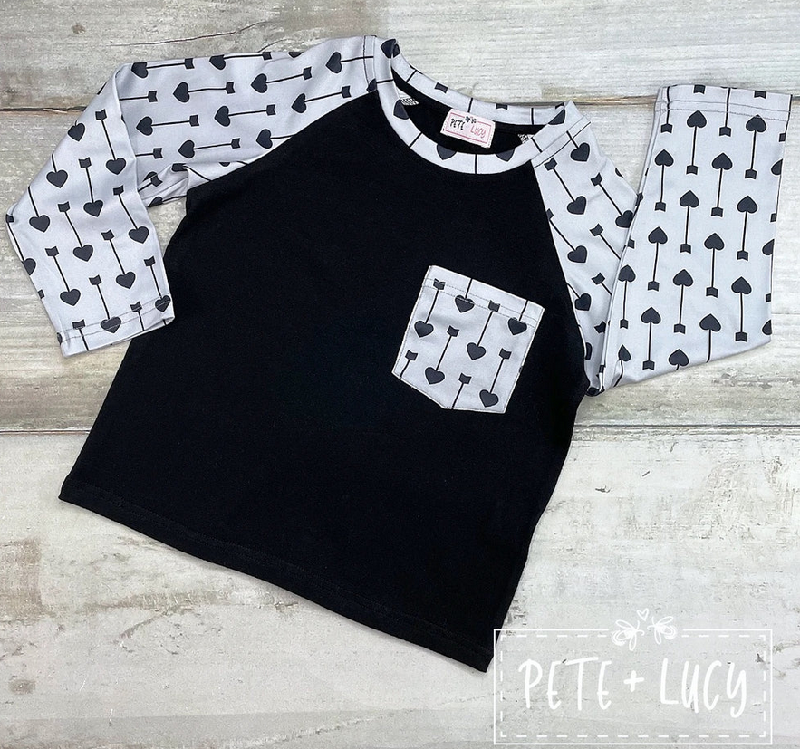 Black and gray raglan sleeve Wild Boy Shirt with heart and arrow pattern.