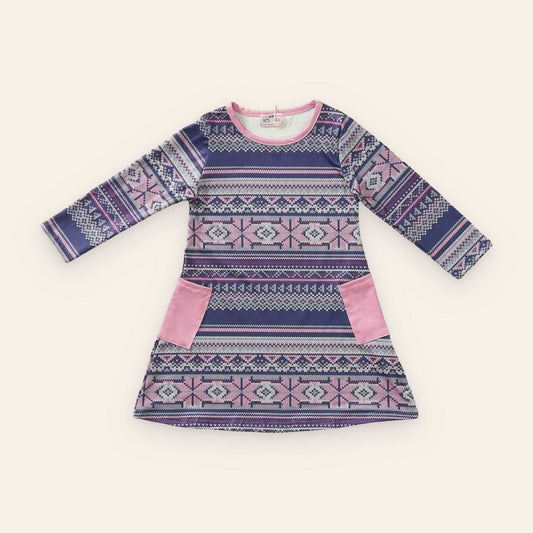 Nordic Frost Dress with Nordic pattern and pink accents on a wooden background.