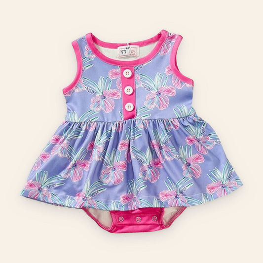 Paradise romper with vibrant floral design, sleeveless, pink accents, and button details.