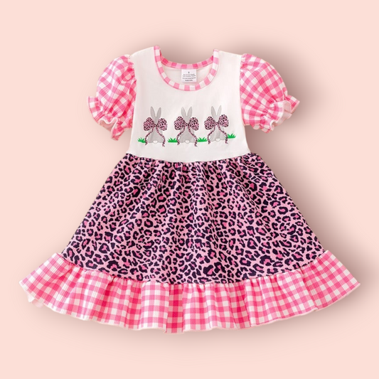 Little girl wearing pink cheetah Easter Bunny dress with gingham sleeves and ruffle hem
